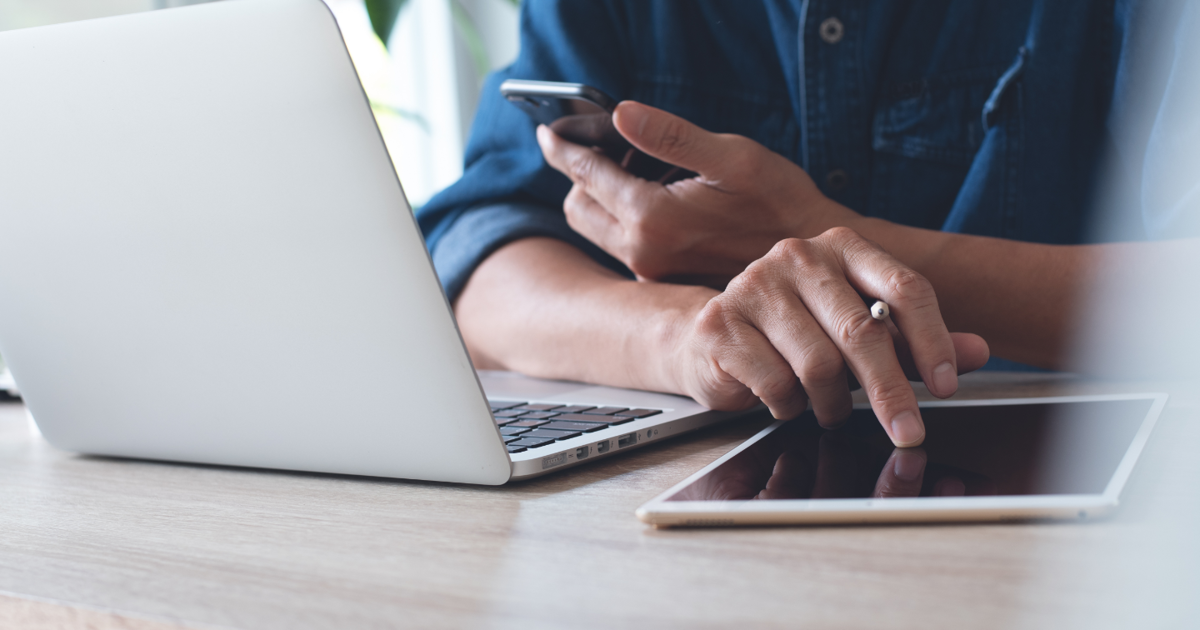Man using mobile phone, tablet and laptop.