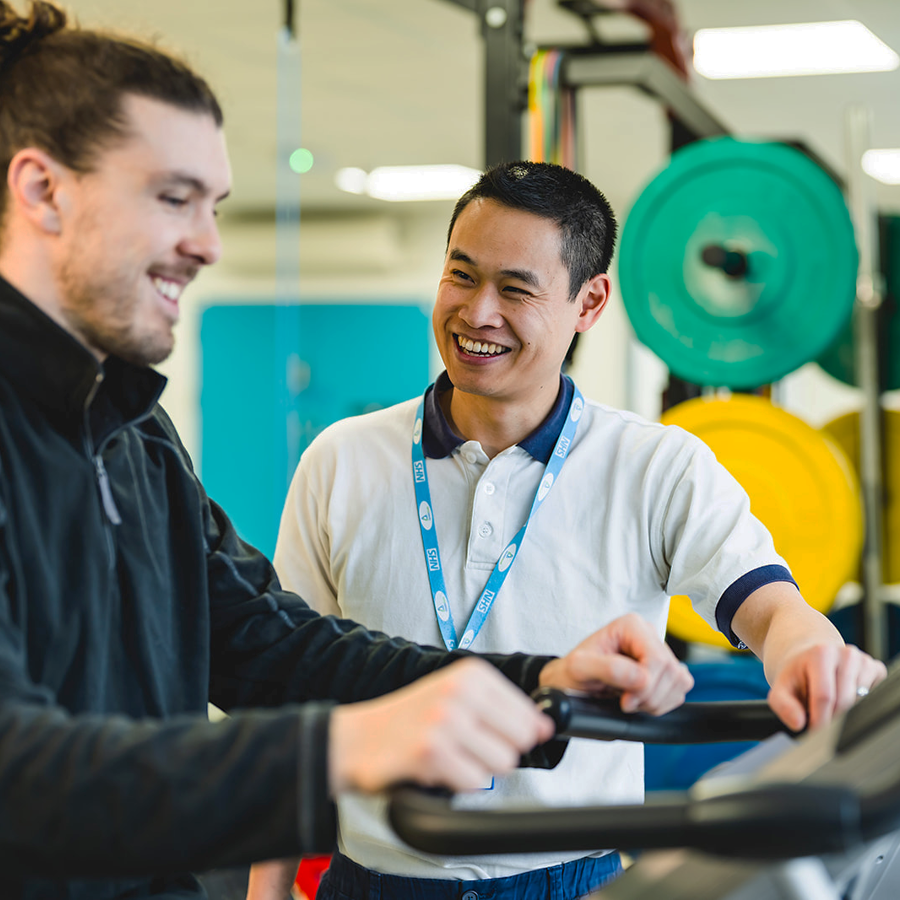 Physiotherapist helping patient on treadmill