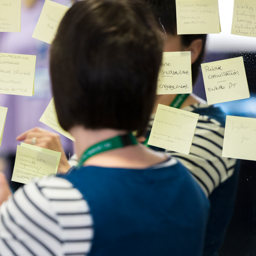 Woman placing post-it notes onto a mirror