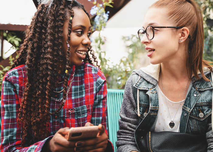 Two teenage girls sat outside talking
