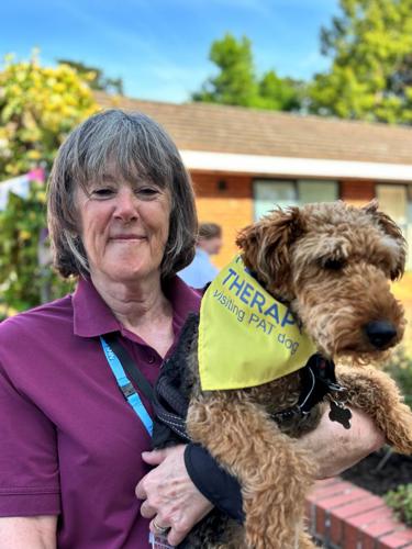 Volunteer holding a therapy dog