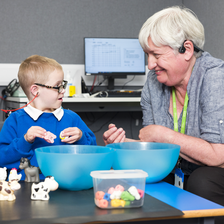 Clinician playing with Down Syndrome child and smiling
