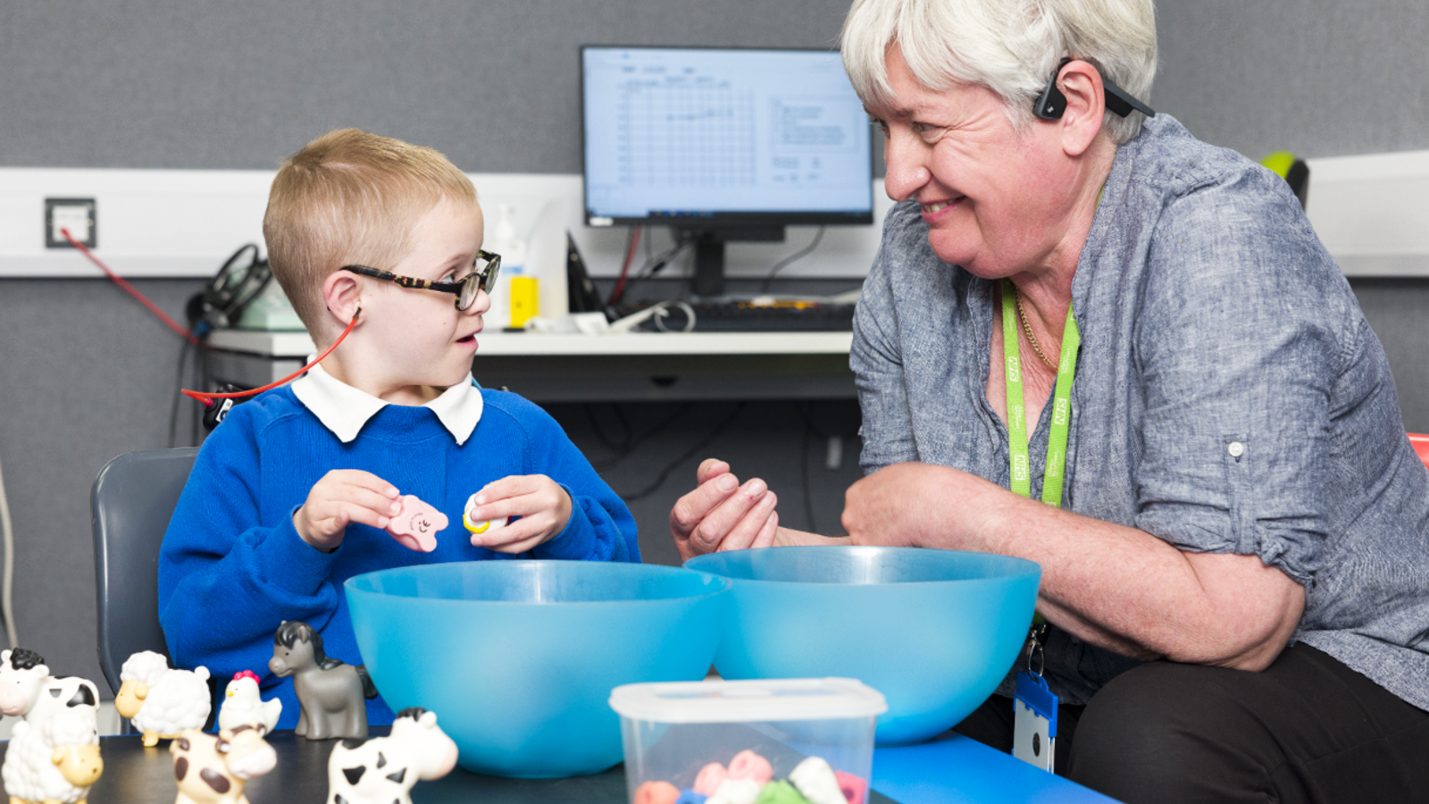 Clinician smiling and playing with a child with Down Syndrome.