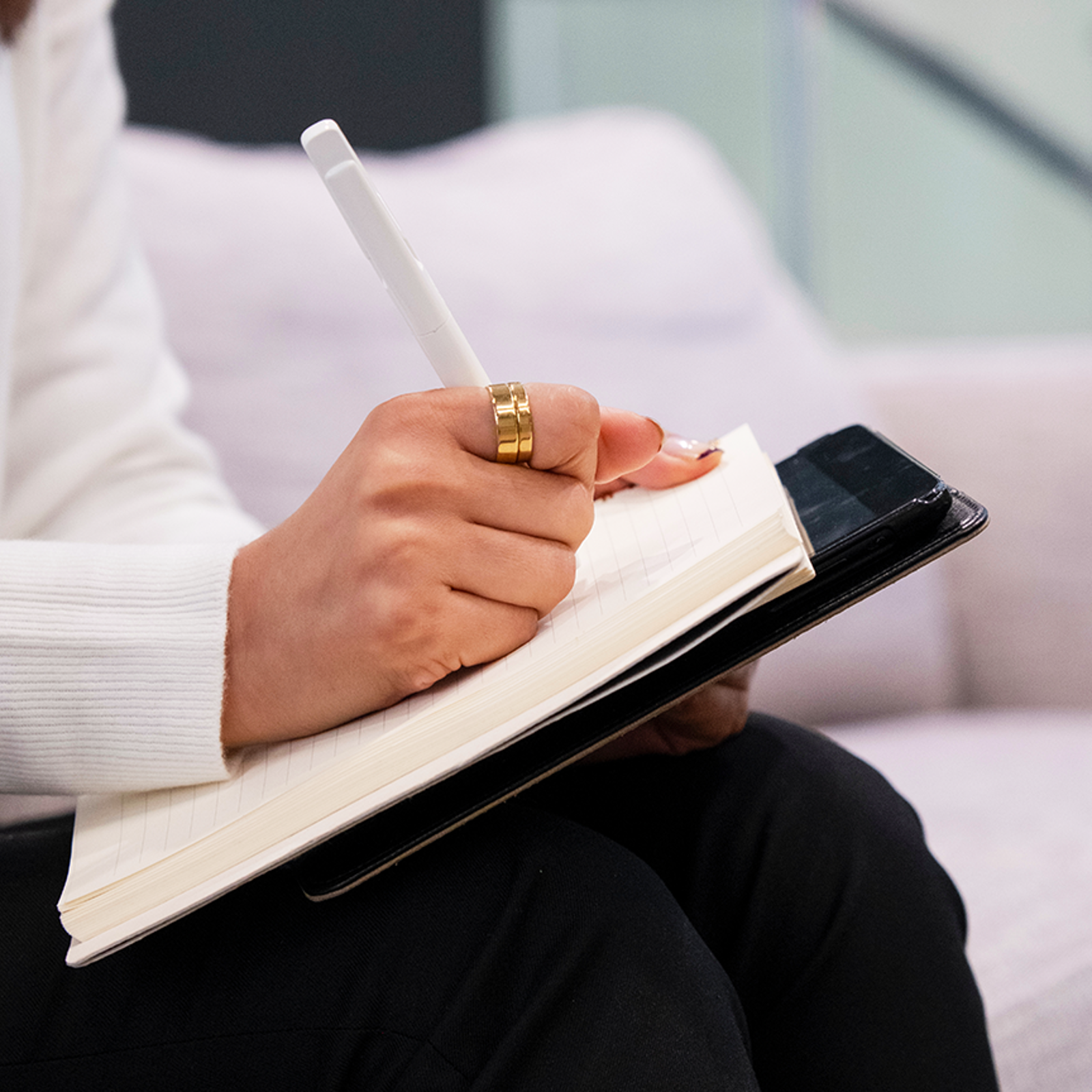 Close-up of woman writing on a notepad