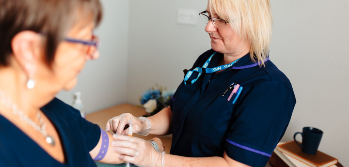 Nurse Taking Blood From Patient In Their Home In Virtual Ward