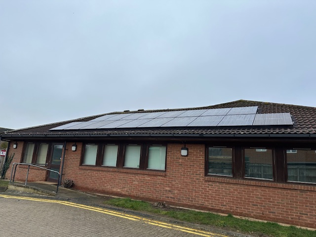 A shot of the front of Parkview Hospital. There are new solar panels installed on the roof. The sky is cloudy.