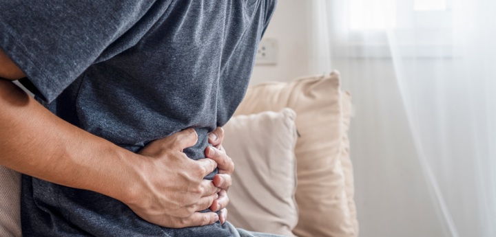 Man having stomach pain on a sofa.