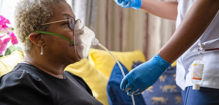 Nursing monitoring the breathing of patient in the patients home.