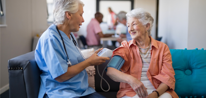 Nursing measuring the blood pressure of an elderly female patient.