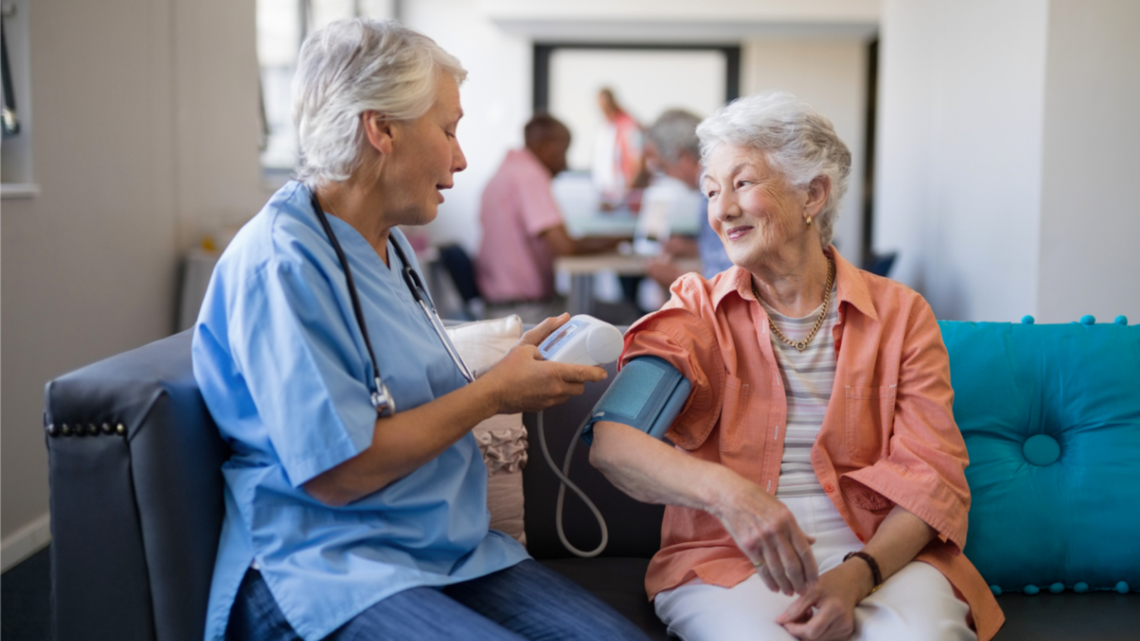 Nursing measuring the blood pressure of an elderly female patient.