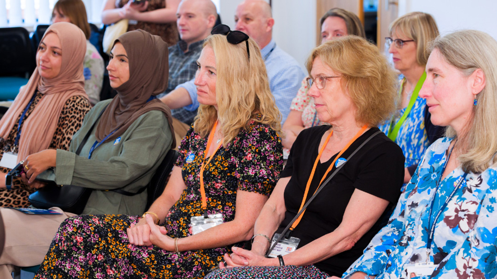 NHS staff members sitting and listening at a conference.