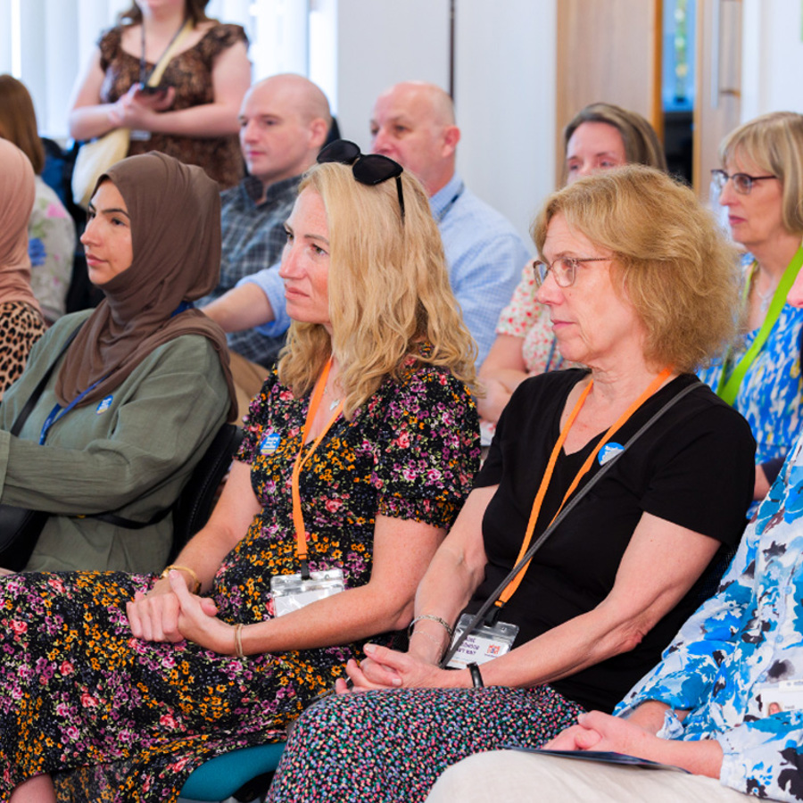 NHS staff members sitting and listening at a conference.